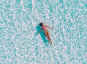 air view of a woman in bikini laying on water