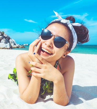  Head Shot of a girl on smiling at the camera, on the beach